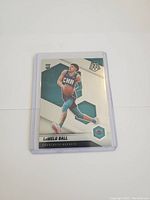 Front of the LaMelo Ball rookie card showing player in Charlotte Hornets uniform with mosaic hexagonal design and rookie card logo.