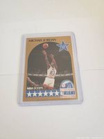 Front image of the 1990 Michael Jordan NBA Hoops card showcasing Jordan shooting a basketball during a game and all-star branding.