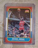 Front of card showing Michael Jordan in Bulls red uniform performing dunk, Fleer logo in top right, card edges and corners visible in sleeve