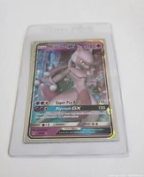 Front of Mewtwo GX full art Pokemon card in clear protective sleeve showing card art and details.