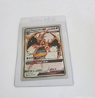 Front photo of full art Naganadel GX Pokémon card in a clear protective sleeve, showing artwork, HP, and attack details.