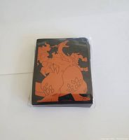 Front view of pack of 65 card sleeves with orange Pokemon illustration on black background