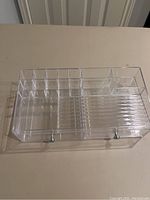 Top view of clear acrylic cosmetic organizer showing compartments and drawers.
