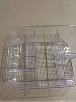 Top-down view of clear plastic cosmetic organizer showing multiple internal vertical dividers and textured bottom base