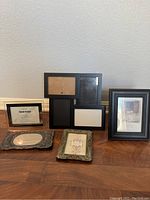 All five frames arranged upright against a wall on wooden floor showing varying shapes, sizes and colors.