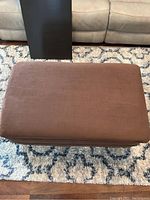 Top view showing dark brown fabric surface of rectangular ottoman