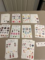 Full overview of all ten sheets of Planner Perfect sticker sets arranged in two rows on a table showing the variety of designs and colors.