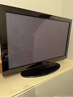Front view of Samsung 42-inch TV on base stand showing the glossy screen and bezel with Samsung logo.