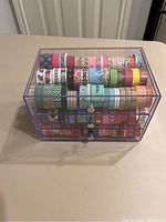 Front view of the acrylic organizer showing three drawers filled with various washi tapes in different patterns and colors.