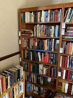 Full view of the wooden bookcase filled with books, showing the adjustable shelves and overall design.