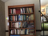 Wide view of four shelves filled with books in German and Latvian.