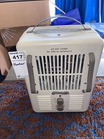 Front view of the heater showing ventilation grilles, control knobs, and handle