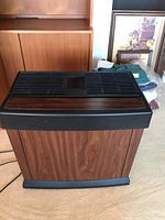 Front angle view of Kenmore floor humidifier showing woodgrain finish, black top vents, and air outlet vent in center.