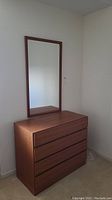 Full view of dresser with mirror mounted on wall