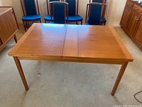 Full view of teak extendable dining table with leaf closed