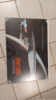 Poster of the Star Trek spaceship Enterprise on a tile floor, showing the whole image including text and graphics.
