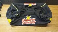 Top view of folded black and yellow duffle bag with Humpty Dumpty logo on side.