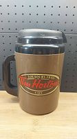 Front view of the brown insulated mug with Tim Hortons logo