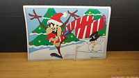 Single placemat photo showing Taz skating with Christmas trees and a snowman