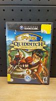 Front cover of Nintendo GameCube Harry Potter Quidditch World Cup game case showing artwork with Harry Potter on broomstick and title.