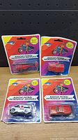 Four Rescue Patrol diecast vehicles still sealed in original blister packaging. Vehicles visible are a red helicopter, a fire truck, a white ambulance, and a rescue vehicle. Packaging features bright colors and Rescue Patrol branding.