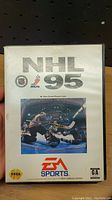 Front cover of Sega Genesis NHL 95 video game case showing logos and artwork.