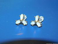 Front view of the pair of vintage marquis white opal stud earrings set in 10 Kt gold with surgical steel posts and plastic backs, showing floral pattern with three gold bead balls in the center