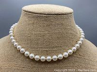 Front view of the knotted pearl necklace displayed on a mannequin bust showing the overall length and pearl uniformity.