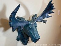 Front-left angle view of the deer stag head sculpture, showing overall shape and color