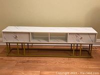 Front view of the entire faux marble storage cabinet showing drawers, open compartments, and metal base