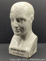 Front and right profile view of ceramic phrenology bust with labeled skull sections and facial features