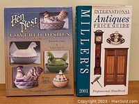 Photo of two antique price guide books side by side: "Glass Hen Nest Covered Dishes - Identification & Value Guide" on the left and "Miller's International Antiques Price Guide - Professional Handbook 2001" on the right.