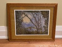 Framed art print featuring a natural landscape with detailed carved wood frame and natural fiber mat, showing overall front view.