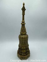 Front view showing full height and tiered base with Buddha figures embossed.
