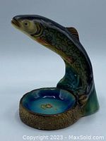 Side view of ceramic fish figurine arched over small dish with Gravenhurst souvenir markings