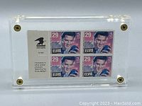 Acrylic display block with four vintage 1992 Elvis Presley 29 cent stamps visible inside, showing front view with screws at corners.