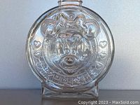 Front side close-up showing the 3D relief of Minnie Mouse with hearts and her name embossed on the glass.