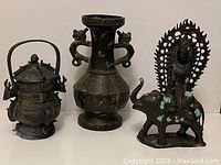 Front view of all three items (incense burner, vase, statue) on display