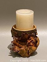 Full view of the pedestal candle holder showing the oak leaf and smiling face with a new pillar candle on top.