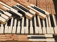 Close view of piano keys showing both white and black keys attached to wooden levers, surface showing some wear and discoloration.