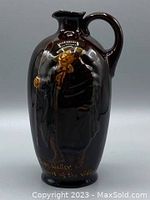 Full front view of brown glazed Tony Weller jug with relief portrait and lettering, showing overall shape and decoration.