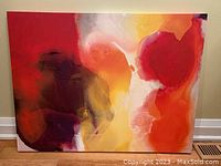 Full view of colourful abstract artwork showing red, yellow, orange, white, and purple hues on plasticized canvas on fibreboard frame.