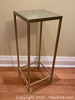 Front angle view showing gold metallic frame and mirror top.
