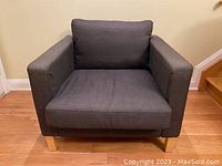 Front angled view of IKEA Karlstad armchair showing fabric and cushion condition