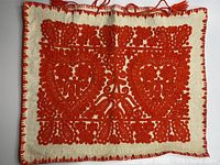 Full view of pillow cover showing two large embroidered hearts and floral motifs in orange thread on cream fabric.