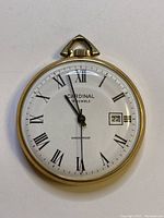 Front view of Cardinal pocket watch showing white dial with Roman numerals, date window, hands, and brand markings.