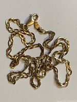 Close-up image of the solid gold chain showing its twisted link design and kinks.