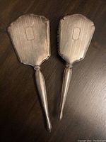 Front view of the comb and brush with silver handles, showing engraved pattern and shapes