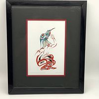 Full view of the framed artwork showing the black frame, red mat, and 'Transformation to Hummingbird' print.