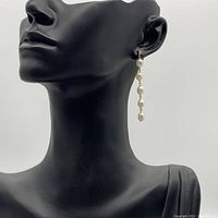Earrings worn on black mannequin showing length and hang style